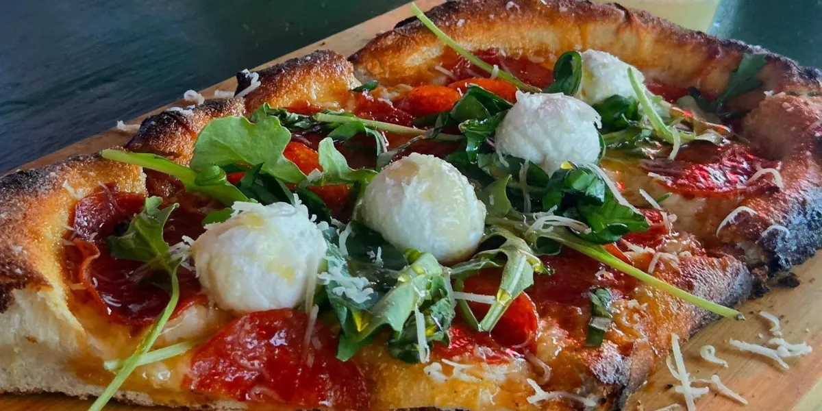 La corteza de una pizza de La Ricetta sobre su tabla